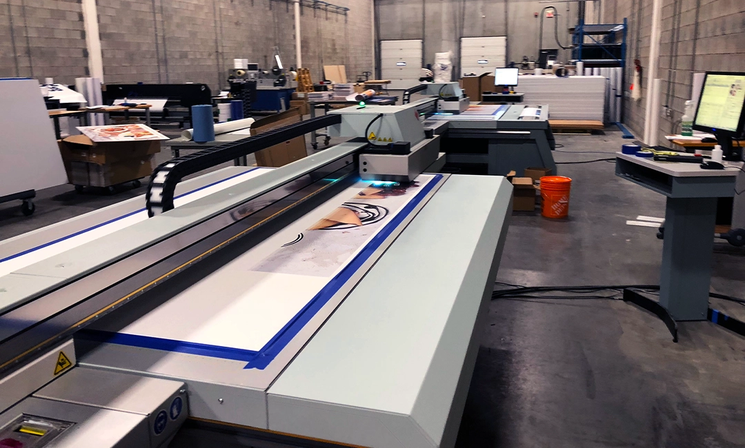 Machine printing design on poster paper in back of print shop